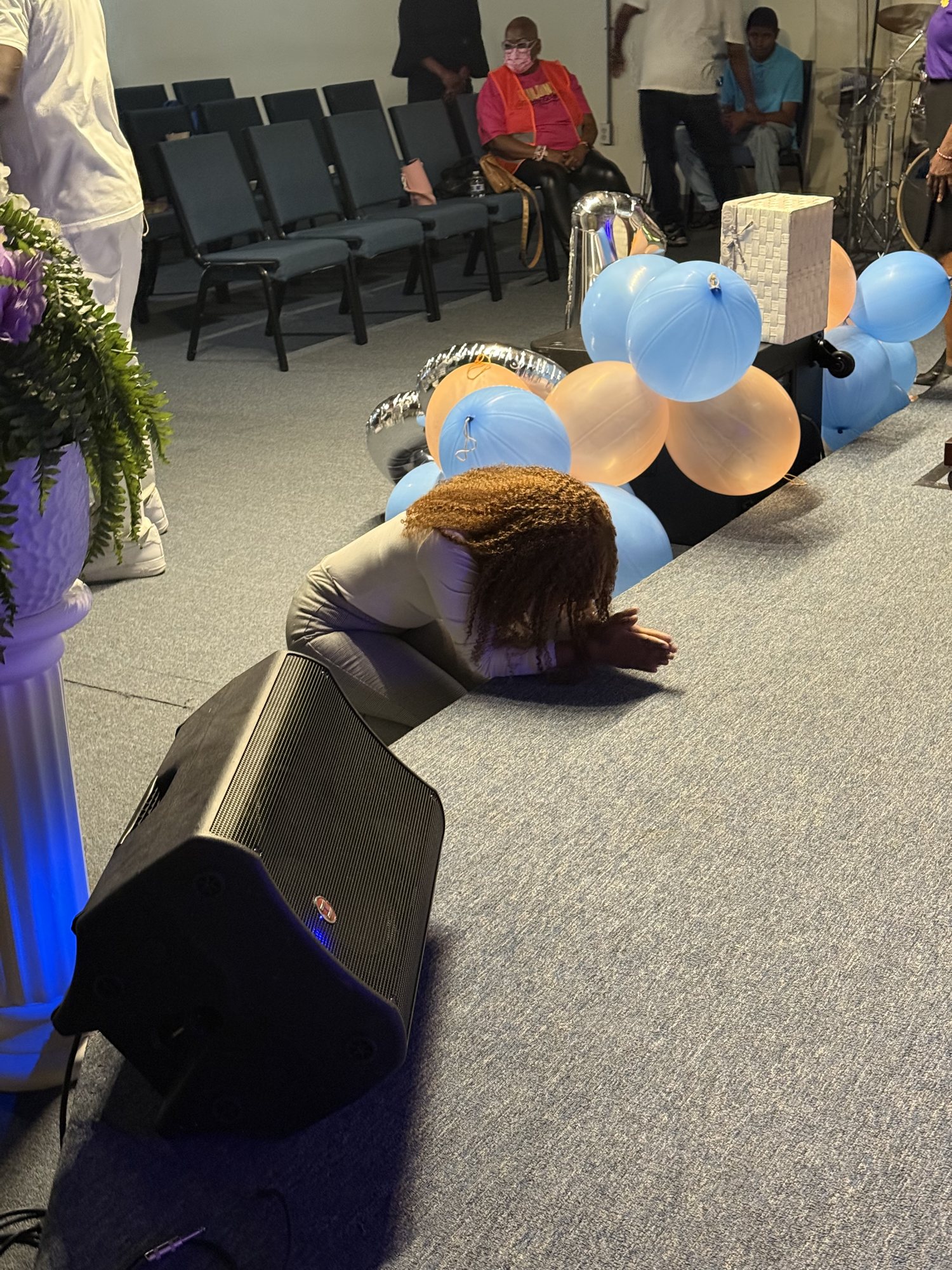 A woman kneeling in prayer at the altar