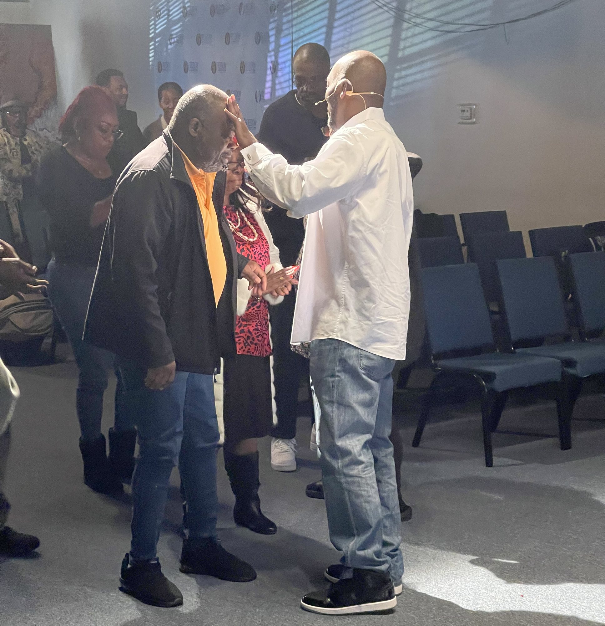Pastor laying hands on a man in prayer at the altar